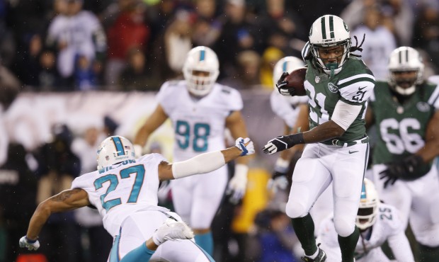 New York Jets running back Chris Johnson (21) avoids a tackle by Miami Dolphins strong safety Jimmy...