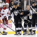 Pittsburgh Penguins' Kris Letang (58) is helped off the ice by teammates Steve Downie (23), and Rob Scuderi (4) after being injured in the second period of an NHL hockey game against the Phoenix Coyotes in Pittsburgh, Saturday, March 28, 2015. (AP Photo/Gene J. Puskar)
