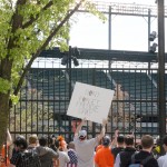 Fans view a Baltimore Orioles baseball game against the Chicago White Sox's, Wednesday, April 29, 2015, from outside of Camden Yards in Baltimore. The game was played in an empty Oriole Park at Camden Yards amid unrest in Baltimore over the death of Freddie Gray at the hands of police. (AP Photo/Matt Rourke)