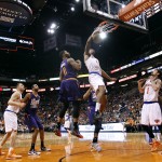 New York Knicks' Lance Thomas, center, dunks over Phoenix Suns' Markieff Morris (11) as the Knicks' Alexey Shved (1), of Russia, looks on during the first half of an NBA basketball game, Sunday, March 15, 2015 in Phoenix. (AP Photo/Ralph Freso)