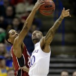 Stanford's Anthony Brown, left, beats Kansas's Naadir Tharpe (10) to a rebound during the second half of a third-round game at the NCAA college basketball tournament Sunday, March 23, 2014, in St. Louis. Stanford won the game 60-57. (AP Photo/Charlie Riedel)
