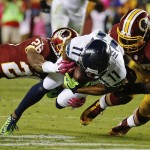 Washington Redskins strong safety Bashaud Breeland (26) and inside linebacker Perry Riley (56) knock Seattle Seahawks wide receiver Percy Harvin (11) to the turf during the first half of an NFL football game in Landover, Md., Monday, Oct. 6, 2014. (AP Photo/Alex Brandon)