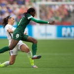 Nigeria's Asisat Oshoala (8) leaps past United States' Lauren Holiday as she chases the ball during the first half of a FIFA Women's World Cup soccer game Tuesday, June 16, 2105, in Vancouver, British Columbia, Canada. (Darryl Dyck/The Canadian Press via AP)