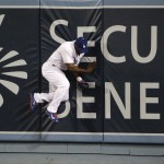 Los Angeles Dodgers' Yasiel Puig hits the wall after catching a ball hit by Arizona Diamondbacks' Yasmany Tomas during the sixth inning of a baseball game, Tuesday, June 9, 2015, in Los Angeles. (AP Photo/Jae C. Hong)
