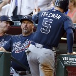 Atlanta Braves manager Fredi Gonzalez celebrates with Freddie Freeman (5) after Freeman scored in the first inning on a double by Nick Markakis during a baseball game against the Arizona Diamondbacks, Tuesday, June 2, 2015, in Phoenix. (AP Photo/Rick Scuteri)