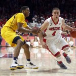 Arizona guard T.J. McConnell (4) drives on California guard Tyrone Wallace during the second half of an NCAA college basketball game, Thursday, March 5, 2015, in Tucson, Ariz. (AP Photo/Rick Scuteri)