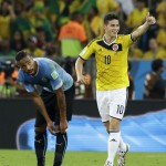 Colombia's James Rodriguez, right, celebrates as he walks past Uruguay's Alvaro Pereira after scoring his side's first goal during the World Cup round of 16 soccer match between Colombia and Uruguay at the Maracana Stadium in Rio de Janeiro, Brazil, Saturday, June 28, 2014. (AP Photo/Matt Dunham)