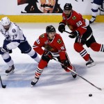 Chicago Blackhawks' Teuvo Teravainen, of Finland, handles the puck as teammate Antoine Vermette, right, and Tampa Bay Lightning's Alex Killorn, left, watch during the first period in Game 3 of the NHL hockey Stanley Cup Final on Monday, June 8, 2015, in Chicago. (AP Photo/Charles Rex Arbogast)