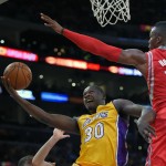 Los Angeles Lakers forward Julius Randle, left, puts up a shot as Houston Rockets center Dwight Howard defends during the first half of an NBA basketball game, Tuesday, Oct. 28, 2014, in Los Angeles. (AP Photo/Mark J. Terrill)