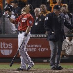 Washington Nationals' Ian Desmond, left, reacts next to home plate umpire Hunter Wendelstedt (21) after striking out against San Francisco Giants pitcher Santiago Casilla during the ninth inning of Game 4 of baseball's NL Division Series in San Francisco, Tuesday, Oct. 7, 2014. The Giants won 3-2 to win the series. (AP Photo/Jeff Chiu)