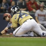 Arizona Diamondbacks' Chris Owings, left, slides in safely at home ahead of the tag by Milwaukee Brewers' Martin Maldonado (12) during the second inning of a baseball game Saturday, May 30, 2015, in Milwaukee. Owings scored on a double by Diamondbacks' Nick Ahmed. (AP Photo/Jeffrey Phelps)