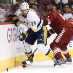 Nashville Predators' Viktor Stalberg (25), of Sweden, skates to the puck after being checked by Arizona Coyotes' John Moore, right, during the first period of an NHL hockey game Monday, March 9, 2015, in Glendale, Ariz. (AP Photo/Ross D. Franklin)