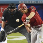 Arizona Diamondbacks' A.J. Pollock, right, hits a solo home run as Los Angeles Dodgers catcher Yasmani Grandal, left, and home plate umpire Gerry Davis watch during the ninth inning of a baseball game, Wednesday, June 10, 2015, in Los Angeles. (AP Photo/Mark J. Terrill)