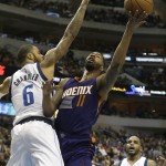 Phoenix Suns forward Markieff Morris (11) shoots against Dallas Mavericks center Tyson Chandler (6) as Jameer Nelson (14) looks on during the first half of an NBA basketball game Friday, Dec. 5, 2014, in Dallas. The Suns won 118-106. (AP Photo/LM Otero)

