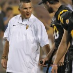 Arizona State coach Todd Graham talks with injured quarterback Taylor Kelly prior to an NCAA college football game against UCLA, Thursday, Sept. 25, 2014, in Tempe, Ariz. (AP Photo/Matt York)
