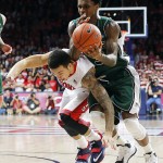 Arizona guard Gabe York (1), left, and Utah Valley guard Donte Williams (3) battle for the ball during the first half of an NCAA college basketball game, Tuesday, Dec. 9, 2014, in Tucson, Ariz. (AP Photo/Rick Scuteri)