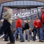 Fans walk past Lucas Oil Stadium before the NCAA Final Four college basketball tournament championship game between Wisconsin and Duke Monday, April 6, 2015, in Indianapolis. (AP Photo/Darron Cummings)