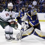 St. Louis Blues goalie Jake Allen, right, comes way out of position to knock a puck away from Minnesota Wild's Matt Cooke during the third period in Game 5 of an NHL hockey first-round playoff series, Friday, April 24, 2015, in St. Louis. The Wild won 4-1. (AP Photo/Jeff Roberson)