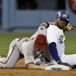  Los Angeles Dodgers' Yasiel Puig, right, is safe under the tag by Arizona Diamondbacks second baseman Aaron Hill after stealing during second inning of a baseball in Los Angeles, Friday, April 18, 2014. (AP Photo/Chris Carlson)