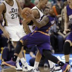 Utah Jazz' Dante Exum, left, cuts off and fouls Phoenix Suns Isaiah Thomas during the second half of an NBA basketball game in Salt Lake City, Saturday, Nov. 1, 2014. The Jazz defeated the Suns 118-91. (AP Photo/George Frey)