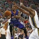 Phoenix Suns' Eric Bledsoe, left, lays the ball in past Utah Jazz' Derrick Favors during the first half of an NBA basketball game in Salt Lake City, Saturday, Nov. 1, 2014. (AP Photo/George Frey)