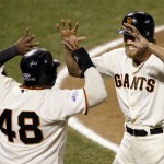 San Francisco Giants' Pablo Sandoval (48) and Hunter Pence celebrate after scoring on a double by Juan Perez during the eighth inning of Game 5 of baseball's World Series against the Kansas City Royals Sunday, Oct. 26, 2014, in San Francisco. (AP Photo/Eric Risberg)