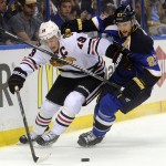 St. Louis Blues' Alex Pietrangelo (27) and Chicago Blackhawks' Jonathan Toews (19) battle for the puck during the first period in Game 2 of a first-round NHL hockey playoff series, Saturday, April 19, 2014, in St. Louis. (AP Photo/Bill Boyce)