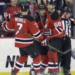 New Jersey Devils' Scott Gomez celebrates his goal with Jon Merrill (7) and Jaromir Jagr, right, during the first period of an NHL hockey game Monday, Feb. 23, 2015, in Newark, N.J. (AP Photo/Bill Kostroun)