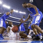 Connecticut forward Phillip Nolan, center, loses the ball between Kentucky's Andrew Harrison, left, and Aaron Harrison, right, during the second half of the NCAA Final Four tournament college basketball championship game Monday, April 7, 2014, in Arlington, Texas. (AP Photo/Eric Gay)