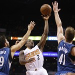 Phoenix Suns guard Eric Bledsoe (2) shoots between Minnesota Timberwolves guard Ricky Rubio (9) and center Justin Hamilton in the third quarter during an NBA basketball game, Wednesday, March 11, 2015, in Phoenix. (AP Photo/Rick Scuteri)