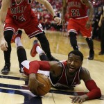 Washington Wizards guard John Wall calls a timeout as he falls to the court with the ball in the second half of Game 3 of an opening-round NBA basketball playoff series against the Chicago Bulls, Friday, April 25, 2014, in Washington. The Bulls won 100-97. (AP Photo/Alex Brandon)