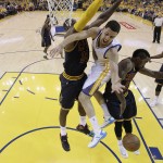 Golden State Warriors guard Klay Thompson, center, loses the ball between Cleveland Cavaliers forward LeBron James, left, and guard J.R. Smith during the first half of Game 5 of basketball's NBA Finals in Oakland, Calif., Sunday, June 14, 2015. (AP Photo/Jeff Chiu, Pool)
