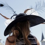 A woman wears a hat before the 141st running of the Kentucky Oaks horse race at Churchill Downs Friday, May 1, 2015, in Louisville, Ky. (AP Photo/Charlie Riedel)