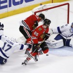 Tampa Bay Lightning goalie Ben Bishop (30) keeps his eye on a loose puck as Chicago Blackhawks' Jonathan Toews and Andrew Shaw (65) watch and Lightning's Alex Killorn (17) slides past during the first period in Game 6 of the NHL hockey Stanley Cup Final series on Monday, June 15, 2015, in Chicago. (AP Photo/Charles Rex Arbogast)