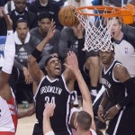 Brooklyn Nets' Paul Pierce, center, drives to the net against Toronto Raptors Patrick Patterson, left, during the first half of Game 1 of an opening-round NBA basketball playoff series, in Toronto on Saturday, April 19, 2014. (AP Photo/The Canadian Press, Darren Calabrese)