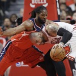 Washington Wizards forward Nene, left, guards Chicago Bulls forward Carlos Boozer during the first half in Game 1 of an opening-round NBA basketball playoff series in Chicago, Sunday, April 20, 2014. (AP Photo/Nam Y. Huh)