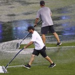 Coors Field grounds crew work to clear puddles of water off the grass in the outfield after a heavy rain storm packing hail swept over the metropolitan area before the first inning of a baseball game between the Arizona Diamondbacks and Colorado Rockies Wednesday, June 24, 2015, in Denver. (AP Photo/David Zalubowski)