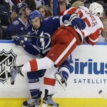 Detroit Red Wings defenseman Danny DeKeyser (65) hits Tampa Bay Lightning center Cedric Paquette (13) during the second period of Game 7 of a first-round NHL Stanley Cup hockey playoff series Wednesday, April 29, 2015, in Tampa, Fla. (AP Photo/Chris O'Meara)