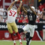 San Francisco 49ers inside linebacker Michael Wilhoite (57) breaks up a pass intended for Arizona Cardinals wide receiver Larry Fitzgerald (11) during the first half of an NFL football game, Sunday, Sept. 21, 2014, in Glendale, Ariz. (AP Photo/Rick Scuteri)
