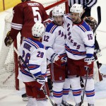 New York Rangers right wing Lee Stempniak (12) celebrates with Dominic Moore (28) and Tanner Glass after scoring during the third period of an NHL hockey game against the Arizona Coyotes, Saturday, Feb. 14, 2015, in Glendale, Ariz. The Rangers won 5-1. (AP Photo/Rick Scuteri)
