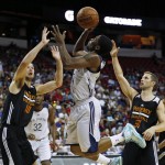 New Orleans Pelicans' Lazeric Jones shoots over Phoenix Suns' Alec Brown, left, and Phoenix Suns' Mickey McConnell during the first half of an NBA summer league basketball game Sunday, July 19, 2015, in Las Vegas. (AP Photo/John Locher)
