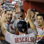 St. Louis Cardinals' Daniel Descalso (33) celebrates in the dugout after scoring against the Arizona Diamondbacks during the 10th inning of a baseball game Friday, Sept. 26, 2014, in Phoenix. The Cardinals won 7-6 in 10 innings. (AP Photo/Ross D. Franklin)