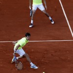 French pair Julien Benneteau, rear, and Edouard Roger-Vasselin return the ball to Spanish pair Marcel Granollers and Marc Lopez during their final match of the French Open tennis tournament at the Roland Garros stadium, in Paris, France, Saturday, June 7, 2014. (AP Photo/Darko Vojinovic)