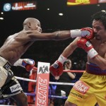 Floyd Mayweather Jr., left, hits Manny Pacquiao, from the Philippines, during their welterweight title fight on Saturday, May 2, 2015 in Las Vegas. (AP Photo/Isaac Brekken)