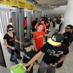 Fans pass through metal detectors as they enter Marlins Park for the season opener for the Miami Marlins and the Atlanta Braves in their baseball game in Miami, Monday, April 6, 2015. (AP Photo/Joe Skipper)