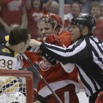 A referee breaks up Boston Bruins left wing Jordan Caron (38) and Detroit Red Wings left wing Justin Abdelkader during the first period of Game 3 of a first-round NHL hockey playoff series in Detroit, Tuesday, April 22, 2014. (AP Photo/Carlos Osorio)