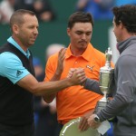 Rory McIlroy of Northern Ireland holds the Claret Jug trophy after winning the British Open Golf championship and shakes hands with runners up Sergio Garcia of Spain, left, and Rickie Fowler of the US at the Royal Liverpool golf club, Hoylake, England, Sunday July 20, 2014. (AP Photo/Peter Morrison)