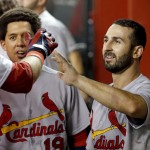 St. Louis Cardinals' Daniel Descalso, right, celebrates with teammates, including Jon Jay, left, after scoring during the 10th inning of a baseball game against the Arizona Diamondbacks on Friday, Sept. 26, 2014, in Phoenix. The Cardinals won 7-6 in 10 innings. (AP Photo/Ross D. Franklin)