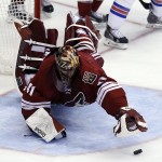 Arizona Coyotes goalie Mike Smith (41) dives for the puck during the first period of an NHL hockey game against New York Rangers, Saturday, Feb. 14, 2015, in Glendale, Ariz. (AP Photo/Rick Scuteri)