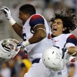Arizona defensive lineman Marcus Griffin (96) and Layth Friekh (58) celebrate after defeating California 49-45 on a last second touchdown during an NCAA college football game, Saturday, Sept. 20, 2014, in Tucson, Ariz. (AP Photo/Rick Scuteri)